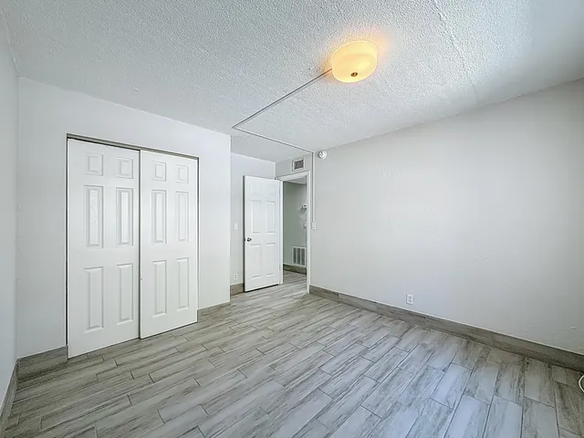 a view of empty room with wooden floor