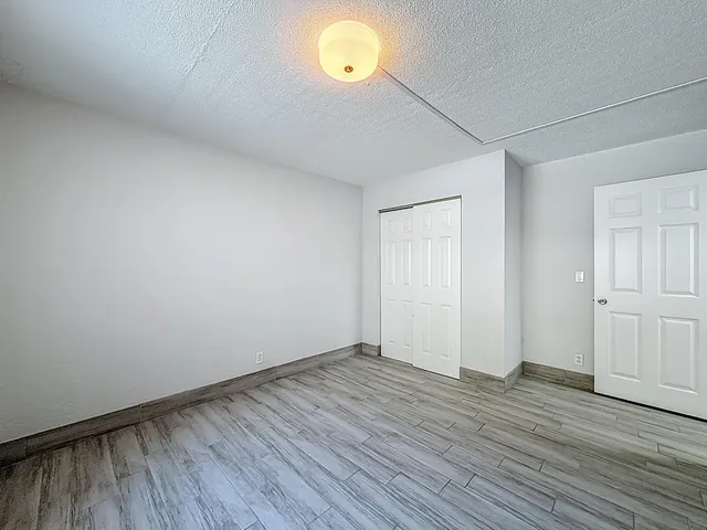 a view of an empty room with wooden floor