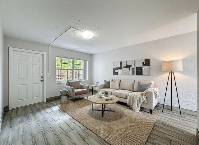 a living room with furniture and wooden floor