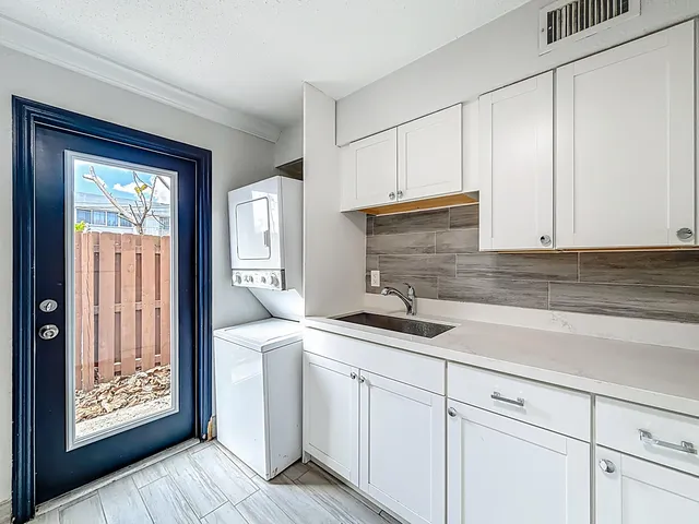 a kitchen with white cabinets and a window