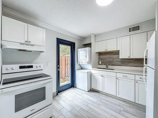 a kitchen with white cabinets stainless steel appliances and sink