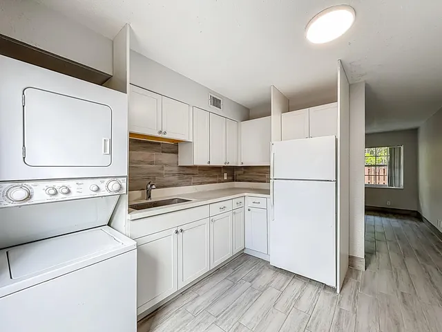 a kitchen with a refrigerator sink stove and cabinets