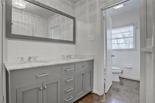 a bathroom with a granite countertop sink and a toilet