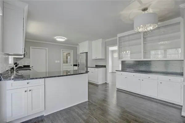 a kitchen with granite countertop white cabinets and white appliances