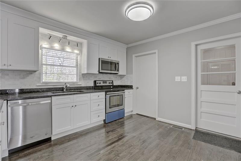 1195 Mt Paran Road Northwest Atlanta, GA 30327 - Photo 10 of 24 a kitchen with granite countertop a stove a sink and a microwave