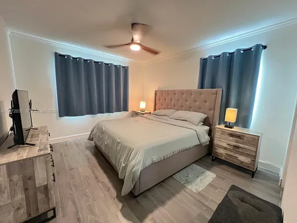 a spacious bedroom with a bed and a dresser