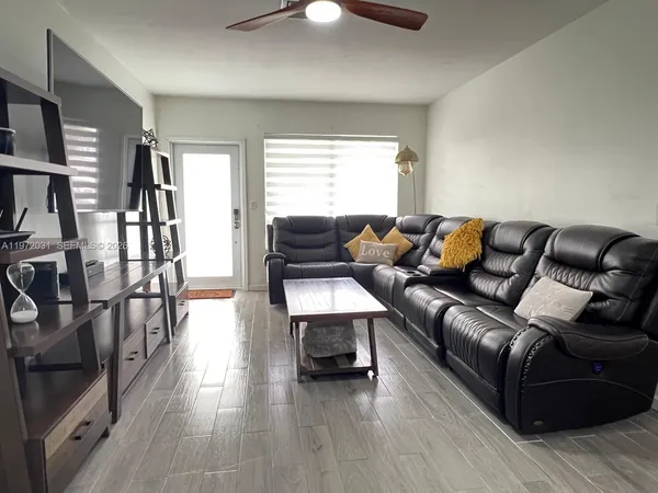 a living room with furniture and a wooden floor