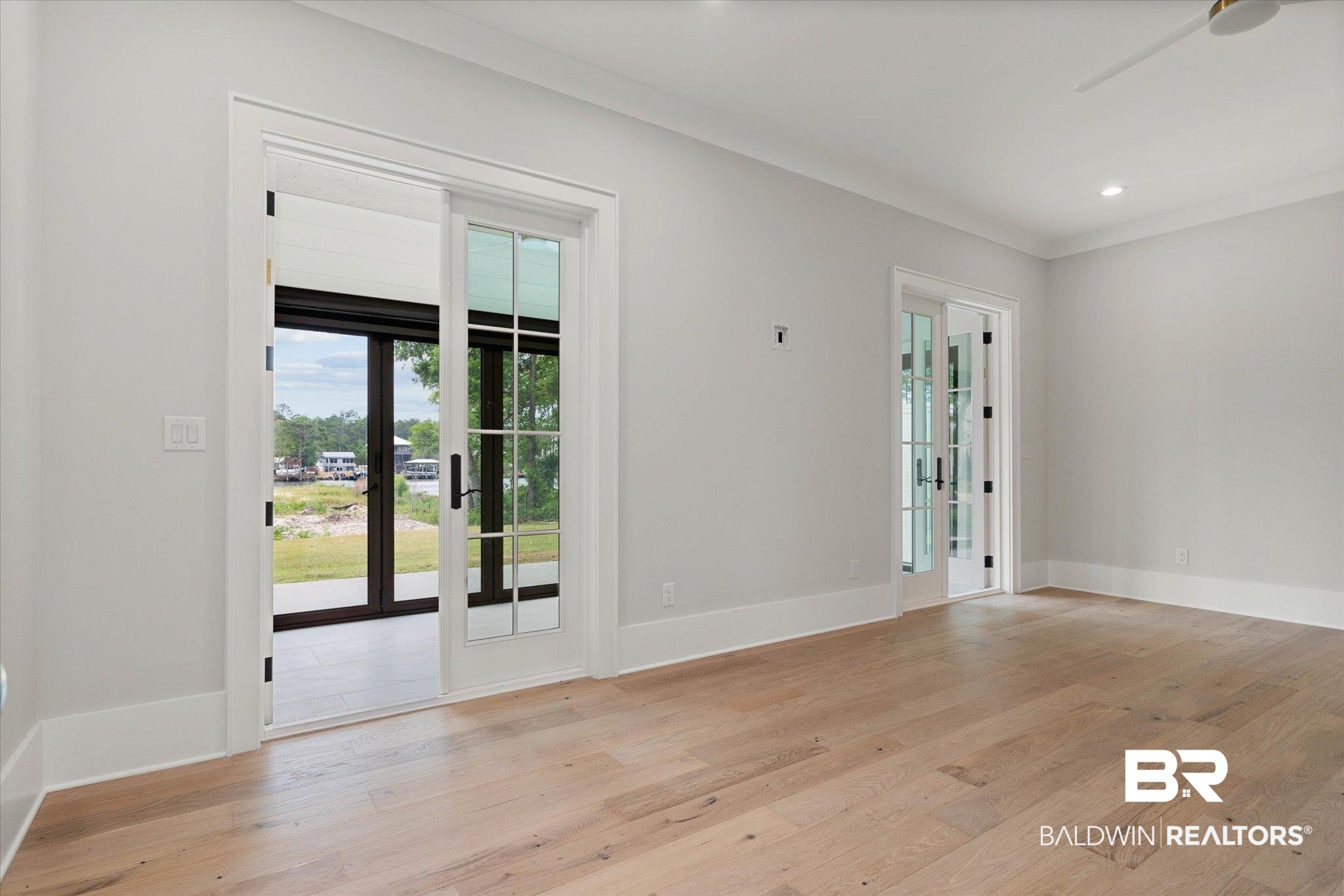 853 Inlet Circle Gulf Shores, AL 36542 - Photo 16 of 55 Spare room with baseboards, a ceiling fan, french doors, and light wood-type flooring