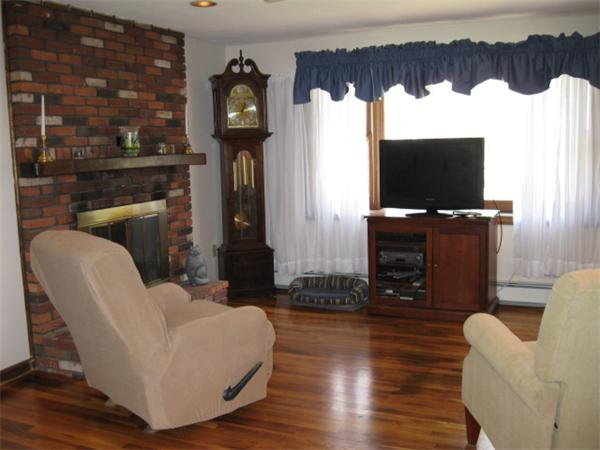 7 Gammons Road Acushnet, MA 02743 - Photo 12 of 20 a living room with furniture a flat screen tv and a floor to ceiling window