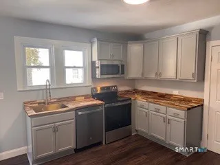 a kitchen with granite countertop a sink stove and cabinets