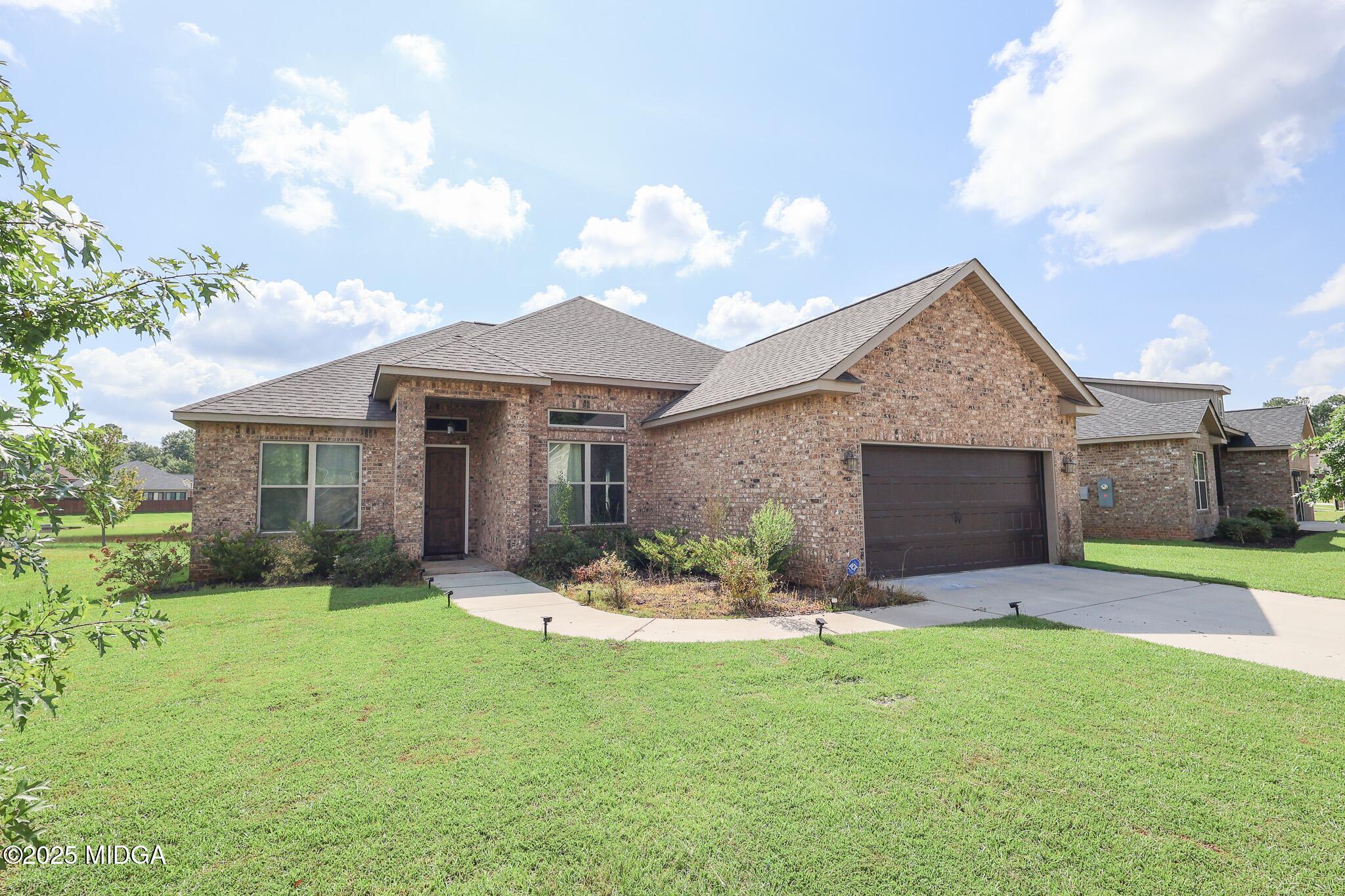 110 Gwendolyn Avenue Perry, GA 31069 - Photo 2 of 23 a front view of a house with a garden and yard