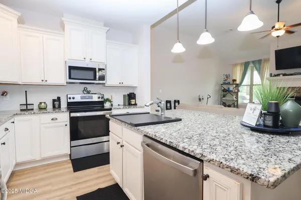 a kitchen with granite countertop a sink a counter and cabinets