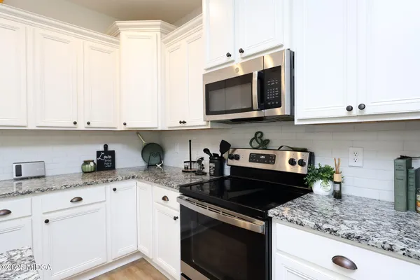 a kitchen with stainless steel appliances granite countertop a sink stove and microwave