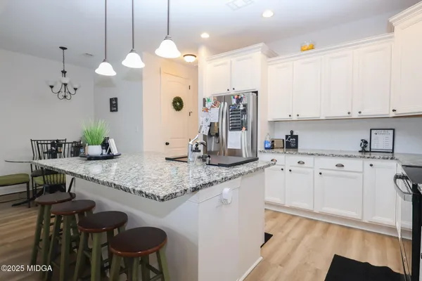a kitchen with stainless steel appliances granite countertop a sink a stove counter space and cabinets