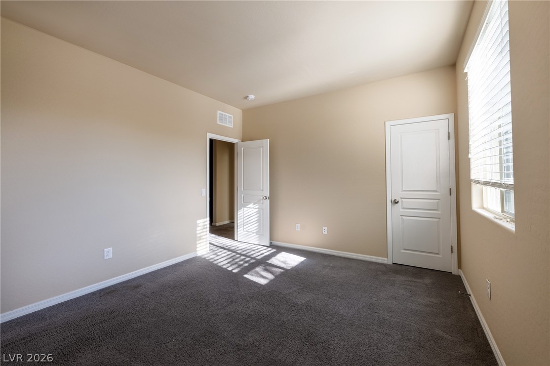 11016 Prairie Grove Road Las Vegas, NV 89179 - Photo 26 of 37 A well-proportioned bedroom with new gray carpeting and natural illumination from a window with blinds.