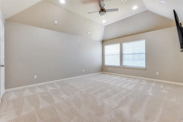 an empty room with a ceiling fan and window