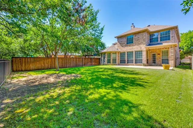 a front view of a house with a yard and trees