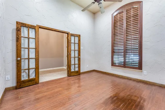 a view of an empty room with a window and wooden floor