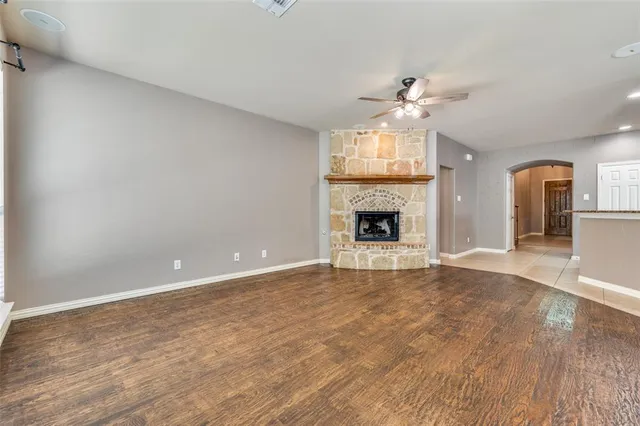 wooden floor fireplace and windows in an empty room