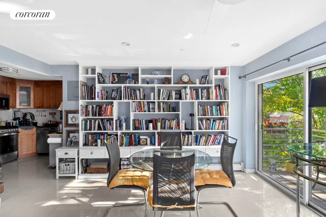 a view of a workspace with furniture and a bookshelf