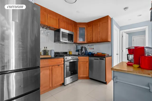 a kitchen with stainless steel appliances granite countertop a refrigerator and a stove top oven