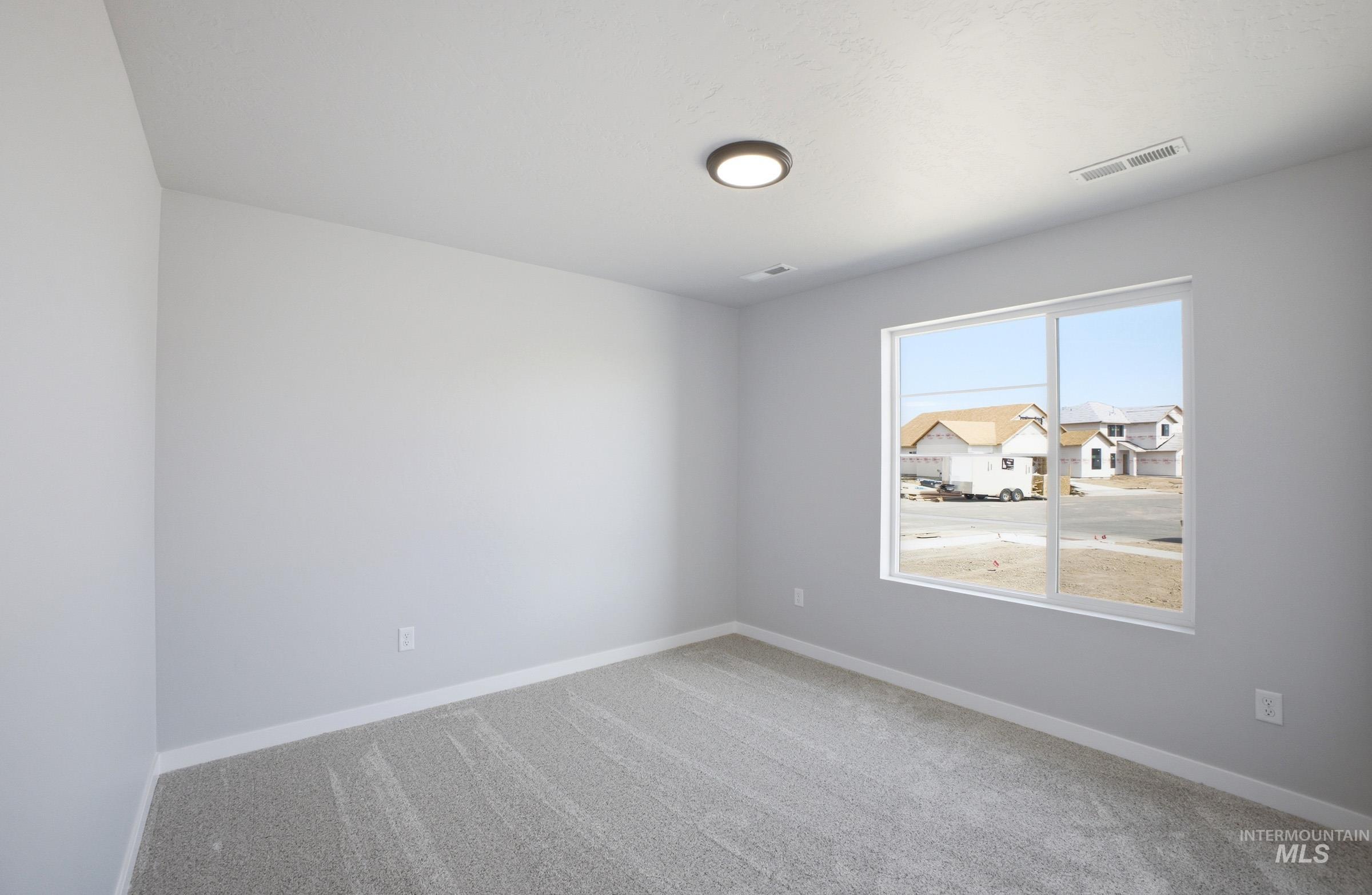 14106 Winding Street Caldwell, ID 83607 - Photo 12 of 18 Spacious room featuring light gray walls, plush gray carpet, and a large window with white framing