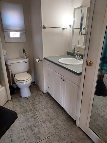 a bathroom with a toilet sink and mirror