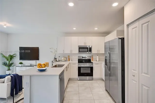 a kitchen with stainless steel appliances a refrigerator sink and stove top oven