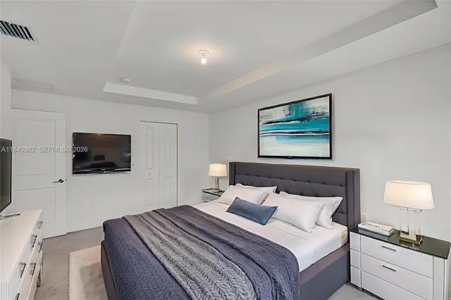 a bedroom with a bed and a flat screen tv