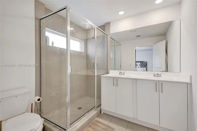 a bathroom with a shower sink mirror and toilet