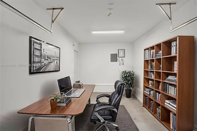 a view of a workspace with furniture and a bookshelf