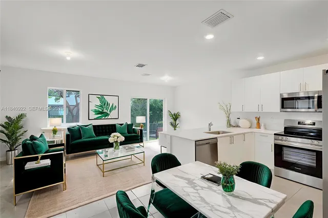 a living room with kitchen island furniture and a potted plant