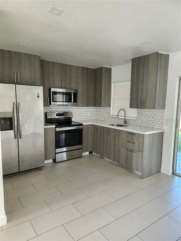 2921 Vasco Street, Unit B Punta Gorda, FL 33950 - Photo 4 of 10 a kitchen with stainless steel appliances a sink a stove a microwave a sink a refrigerator and cabinets