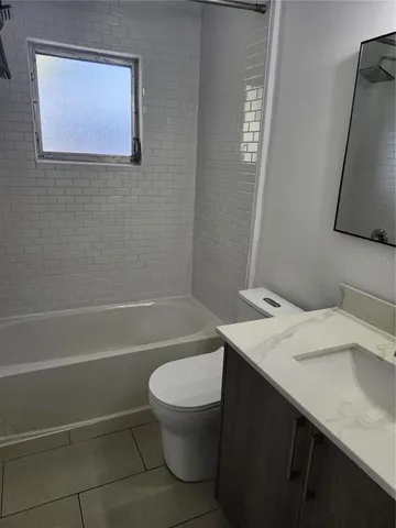 a bathroom with a granite countertop toilet sink and mirror