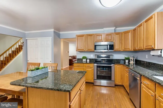 a kitchen with stainless steel appliances granite countertop a sink stove and microwave