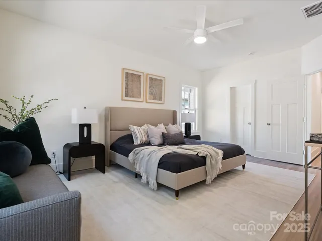 a spacious bedroom with a bed a couch and a window