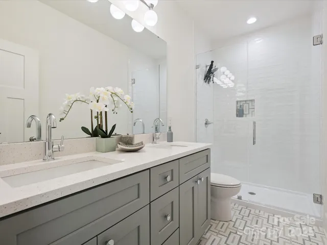 a bathroom with a granite countertop sink a toilet and a mirror