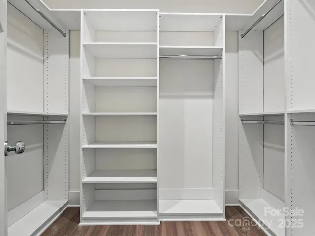 a view of walk in closet with empty racks