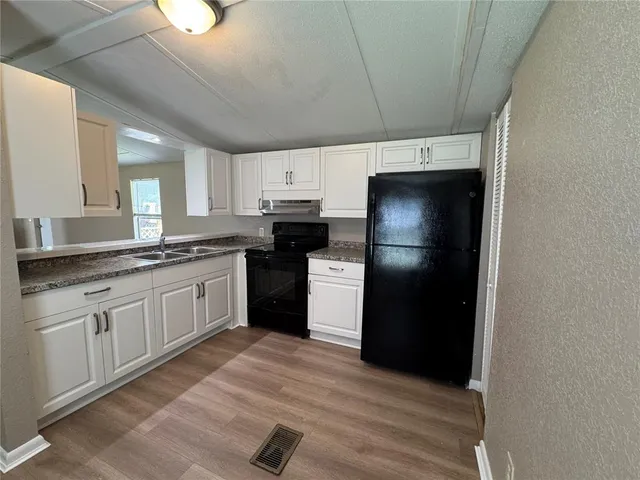a kitchen with a refrigerator and a sink