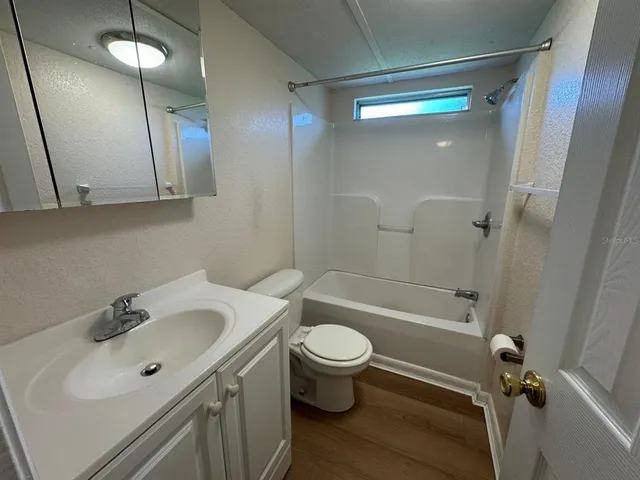 a bathroom with a sink a toilet a mirror and shower