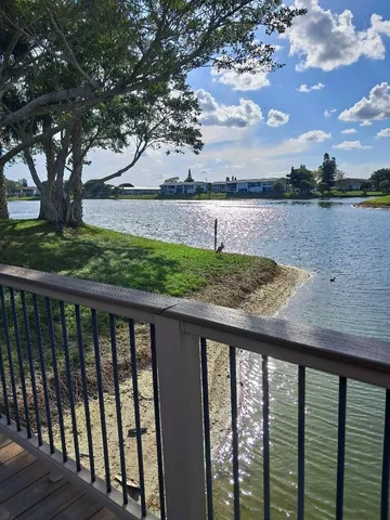 a view of a backyard with table and chairs and a large tree