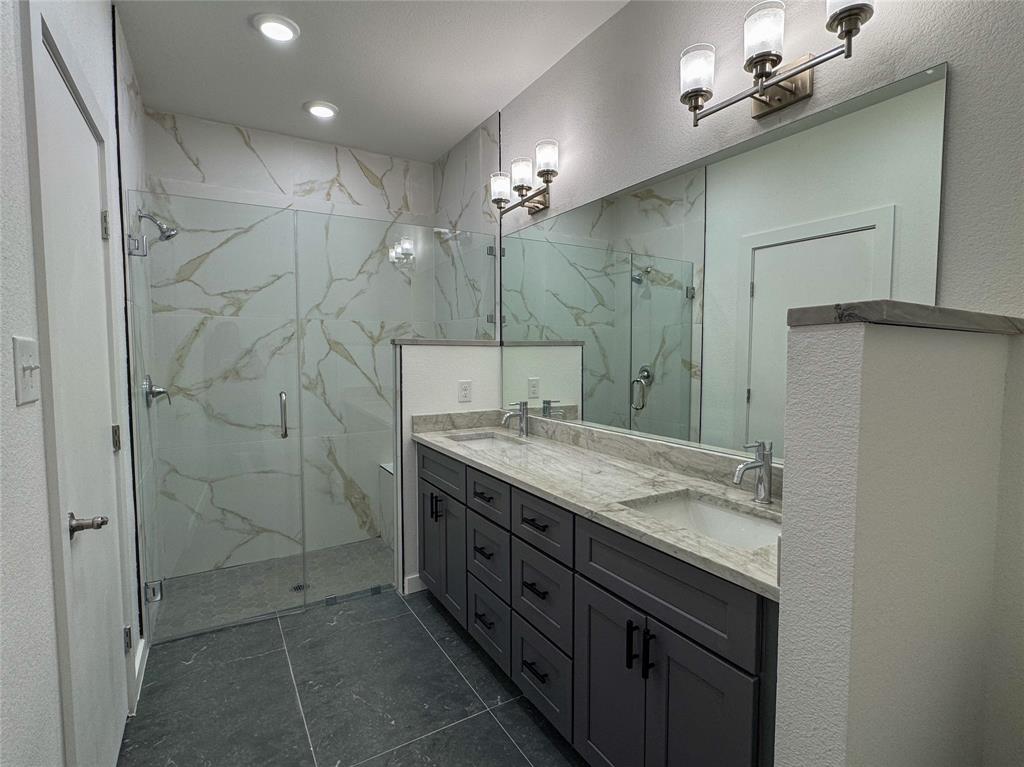 430 Lucy Road Greenville, TX 75402 - Photo 16 of 17 a bathroom with a granite countertop sink a large mirror and a shower