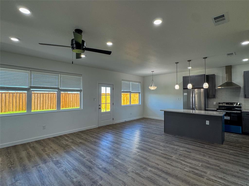 430 Lucy Road Greenville, TX 75402 - Photo 4 of 17 an empty room with wooden floor and windows