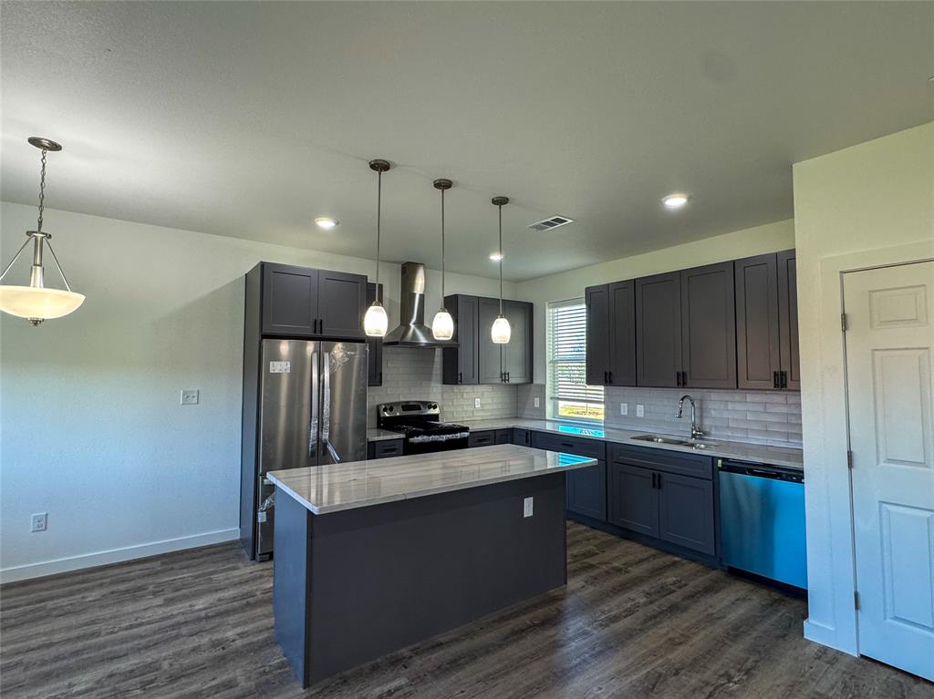 430 Lucy Road Greenville, TX 75402 - Photo 5 of 17 a kitchen with stainless steel appliances granite countertop a sink a stove and a refrigerator