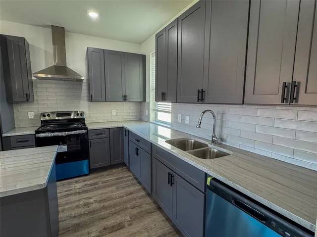 a kitchen with granite countertop stainless steel appliances a sink stove and refrigerator