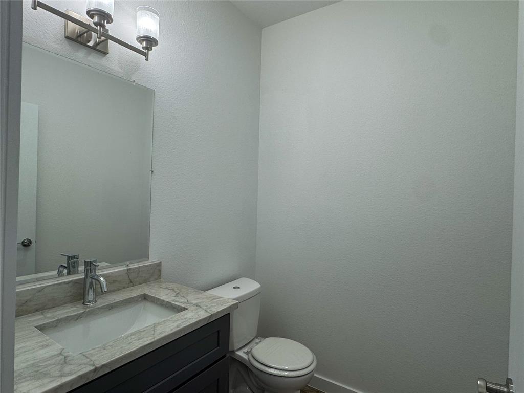 430 Lucy Road Greenville, TX 75402 - Photo 9 of 17 a bathroom with a granite countertop toilet sink and mirror