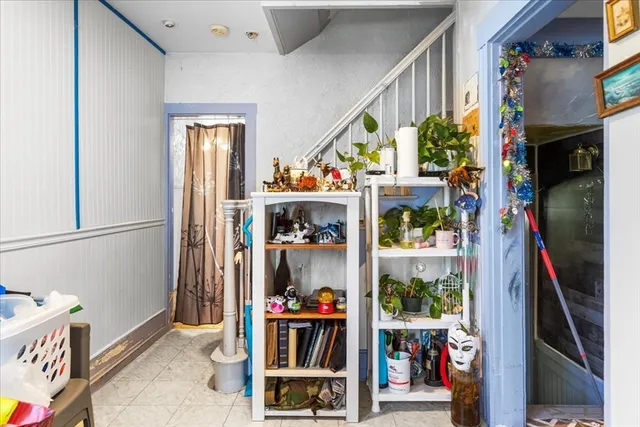 a bedroom with a bed and a potted plant on the dresser