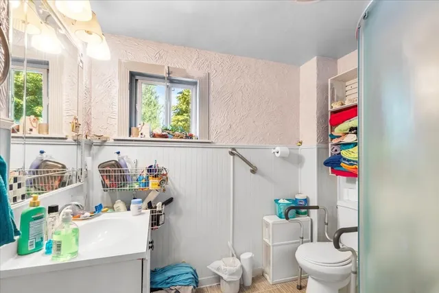 an empty room with chandelier fan and windows