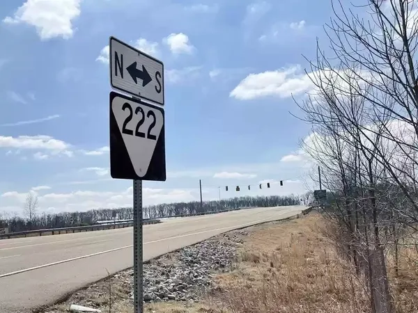 a street sign on a sidewalk next to a road