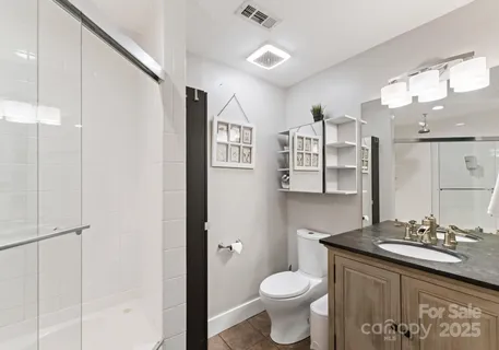 a bathroom with a granite countertop sink toilet and shower